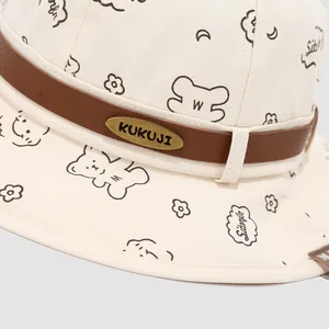 Bob enfant en toile crème avec motifs d'ours et ruban en cuir marron avec plaque