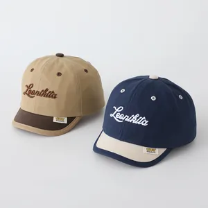 Detail view of cotton baby baseball caps featuring Leonikita embroidery and soft brims