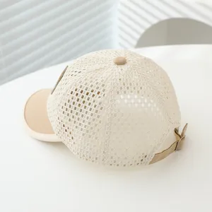 Detailed close-up of breathable mesh fabric and adjustable metal buckle on kids' beige cap