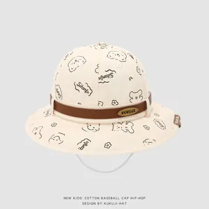 Détail du chapeau bébé avec imprimé ours, sangle brune et mentonnière blanche réglable