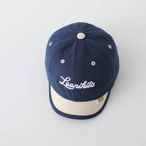 Detail of baby baseball cap featuring contrast brim and Leonikita letter embroidery