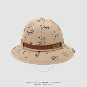 Détail d'un chapeau de soleil en coton kaki pour bébé avec motif ours et logo en métal