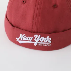 Detalle de gorro de algodón rojo oscuro para bebé con bordado 3D blanco New York