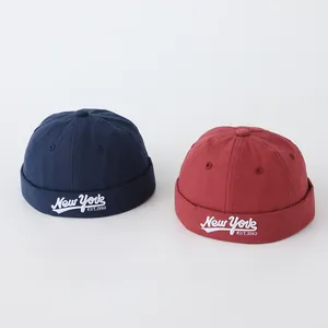 Detalle de gorros docker de algodón con bordado New York en azul marino y rojo ladrillo