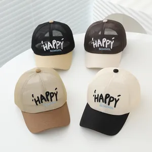 Dettaglio di quattro cappellini da baseball traspiranti per bambini con logo HAPPY SCHOOL
