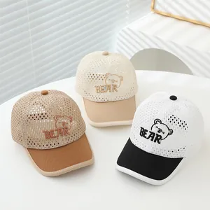 Detailed close-up of breathable mesh fabric and bear embroidery on children's baseball caps