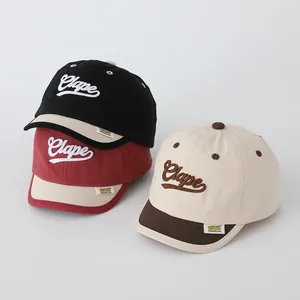 Detailed embroidery of Clape letters and yellow tag on children baseball caps