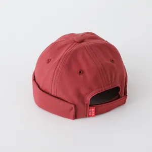 Gorro docker clásico color burdeos para bebé con cierre ajustable y etiqueta de marca
