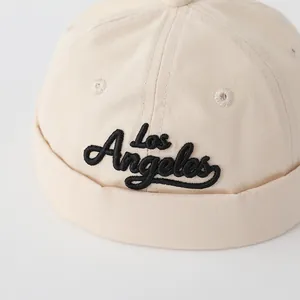 Close-up of beige canvas Docker hat featuring black Los Angeles embroidery detail