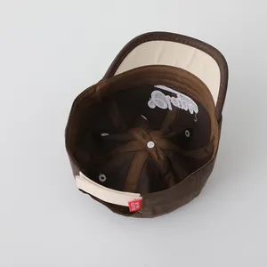 Detail of adjustable strap and inner embroidery on brown two-tone kids baseball cap