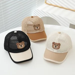 Detailed view of mesh kids' baseball caps with cute cartoon bear patches and sun visor