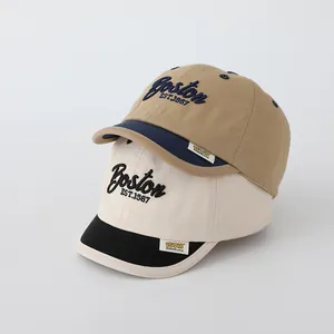 Detail of embroidered Boston letters on retro cotton baseball caps for toddlers
