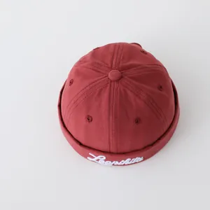 Detalle del gorro vintage de algodón rojo ladrillo con bordado blanco de Leonikit