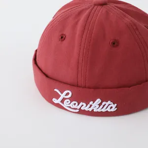 Detalle de tela de algodón con bordado blanco Leonikita en gorro para bebé rojo oscuro