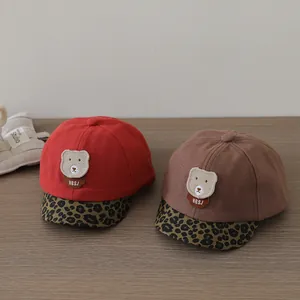 Detailed close-up of baby baseball caps with cute bear patches and leopard print brims