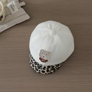 Detailed macro view of baby baseball cap featuring bear patch and leopard print brim