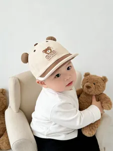 Close-up of baby baseball cap with teddy bear ears, cartoon embroidery and GOOD text detail