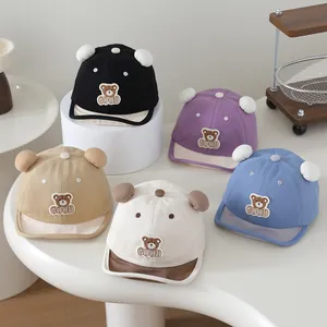Detail of baby baseball caps with 3D ears and cartoon bear embroidery in multiple colors