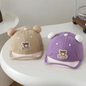 Detail view of khaki and purple baby baseball hats with cute bear patches and ears