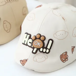 Close-up of baby beige cotton beret featuring a cute bear pattern and 3D He OK label