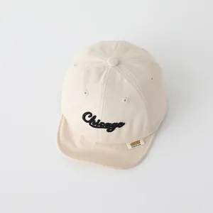 Dettaglio cappellino neonato in cotone beige con ricamo Chicago e visiera morbida