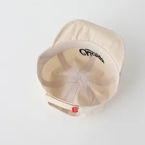 Vista interna del cappellino beige per neonati con ricamo Chicago e cinturino regolabile