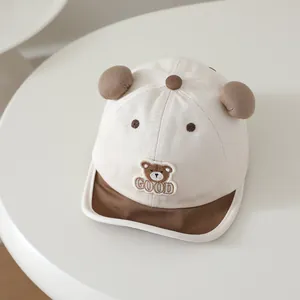 Detailed view of baby baseball cap with 3D ears and cartoon bear embroidery in cream