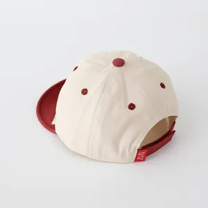 Detail view of cotton baby baseball cap featuring red adjustable strap and embroidery