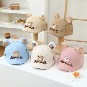 Detailed macro of baby cotton caps featuring cute bear embroidery and 3D ears detail