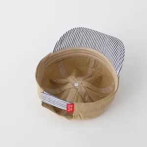 Vista interior detallada de gorra infantil caqui con borde a rayas y banda de sudor