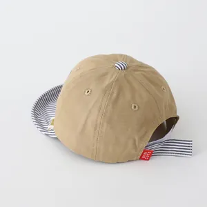 Detalle de gorra de béisbol para bebé en algodón caqui con correa ajustable a rayas azules