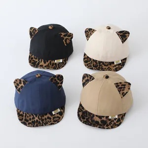 Detail view of baby baseball caps with leopard print ears in black, beige, blue and khaki