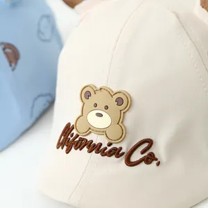 Detailed embroidery of California Co. and bear patch on a beige cotton baby cap