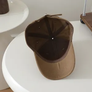 Detail view of the brown canvas baseball cap interior with reinforced seams and air vents
