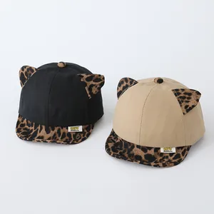 Detail of baby baseball cap with leopard print ears and brim in black and beige