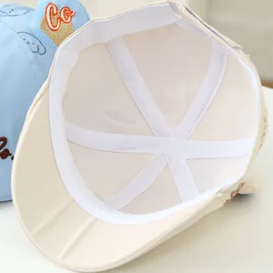 Detailed interior of beige kids baseball cap showing mesh lining and reinforced tape