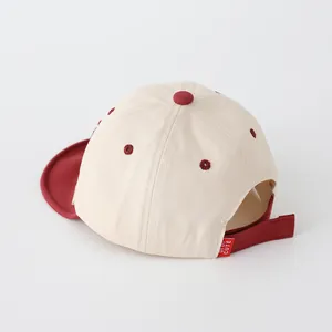 Detail view of adjustable velcro strap and red DTDT CUTE label on baby baseball cap