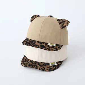 Detail of baby baseball caps with leopard print ears in khaki and beige canvas fabric