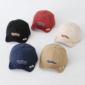 Group display of colorful kids cotton baseball hats with letter embroidery and striped brim
