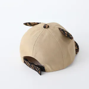 Detail of adjustable velcro strap and leopard print ears on khaki baby baseball cap