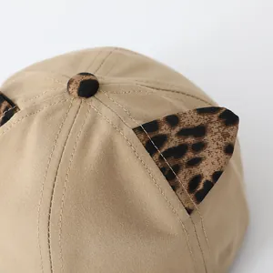 Detail of khaki cotton baby baseball cap featuring leopard print ears and stitching