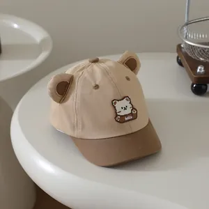 Detail der Baby-Baseballkappe mit 3D-Bärenohren und Hello-Stickerei auf khakifarbenem Canvas
