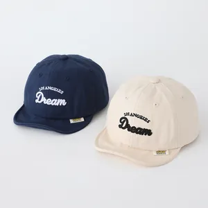 Details von Baby-Baseballkappen in Navy und Beige mit besticktem Los Angeles Dream Text