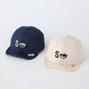 Detail of navy and beige soft brim cotton baseball hats with Smile letter embroidery