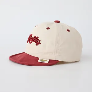 Détail de la casquette bébé RALLY bicolore avec broderie rouge et étiquette tissée