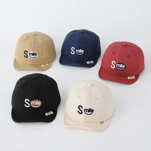 Detail of five cotton baby baseball caps with Smile embroidery in various colors