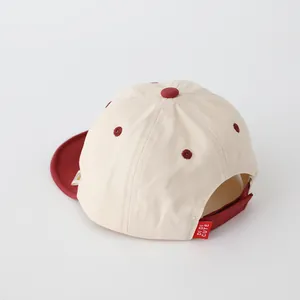 Détail de la sangle velcro rouge réglable et de l'étiquette sur la casquette pour enfants