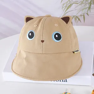 Detail of baby sun hat with cute 3D bear ears and embroidered face on khaki canvas