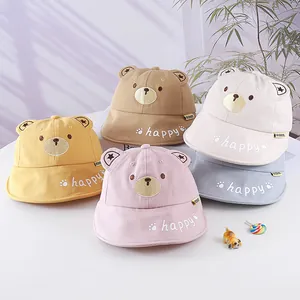 Macro shot showing five colorful cotton sun hats with cute bear ears and happy embroidery
