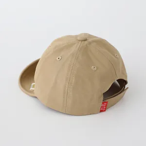 Detail von Klettverschluss und rotem Logo-Label an khakifarbener Kleinkind-Baseballkappe